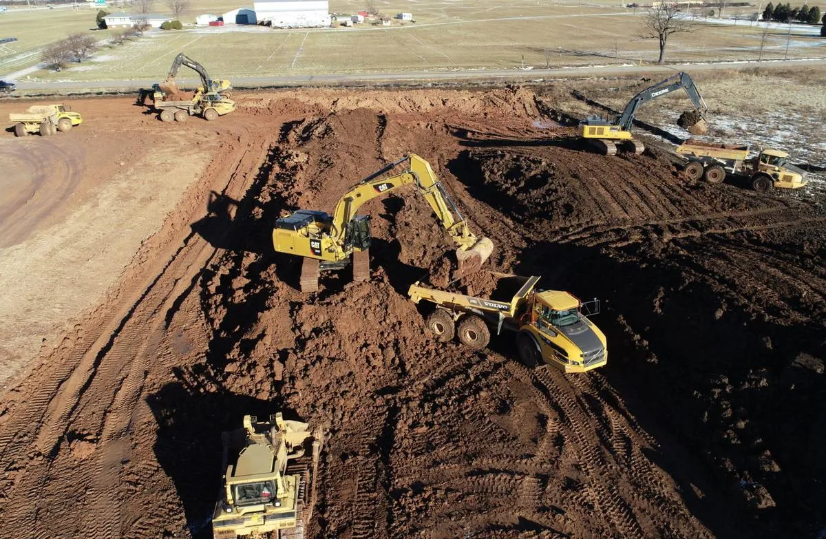 Excavators cutting material and loading articulated haul trucks on a large earthworks site