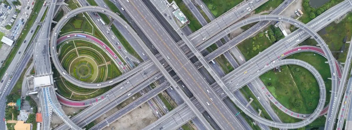 Aerial view of a multi-level highway interchange with looping ramps and landscaped infield